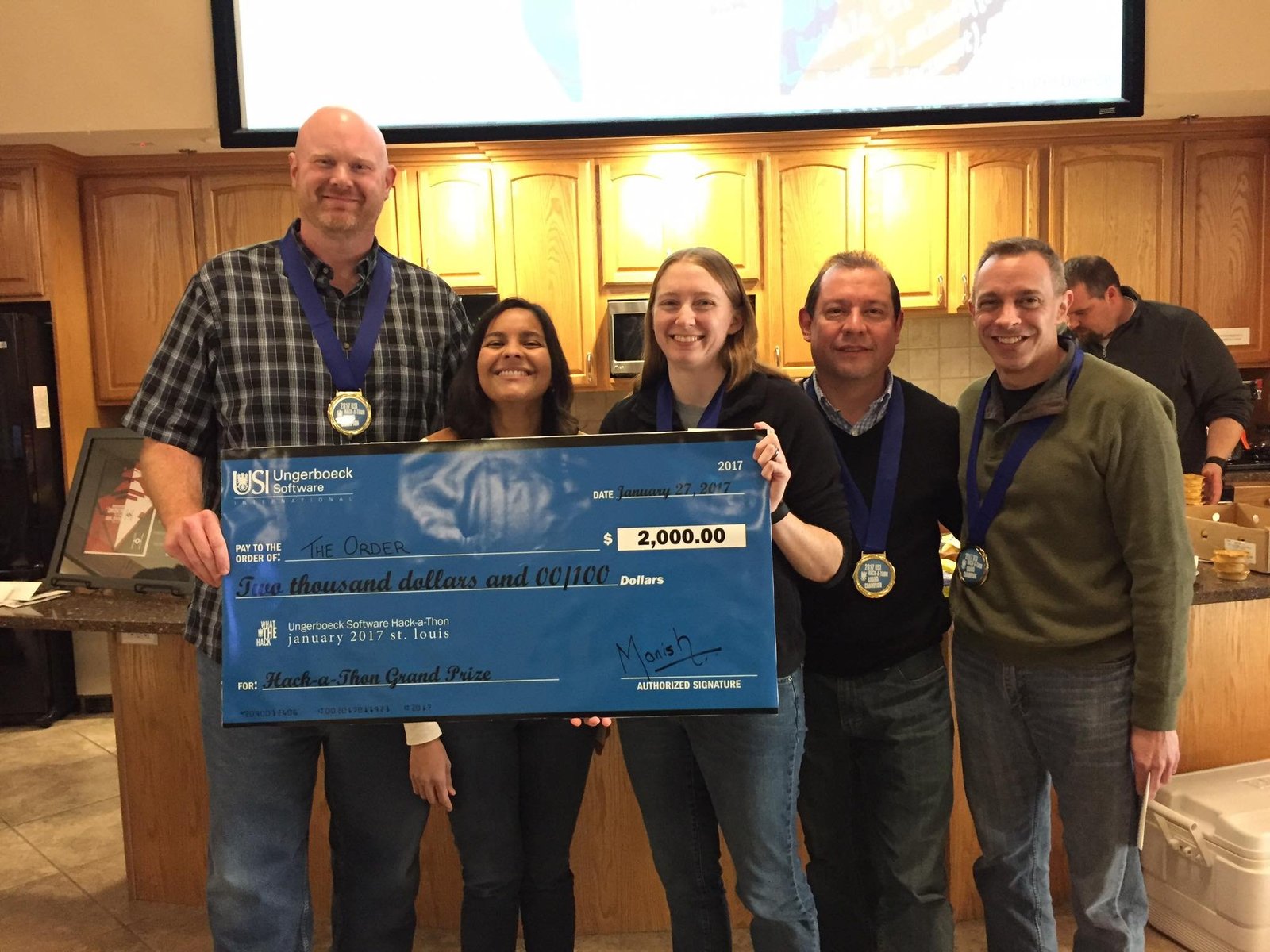 Wayne Lewis, Ronelle Page, Crystal Weaver, Danilo Bernal, and Rob Rebman holding a giant check for winning a Hackathon